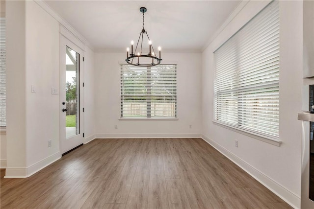 unfurnished dining area with hardwood / wood-style floors, a healthy amount of sunlight, and crown molding