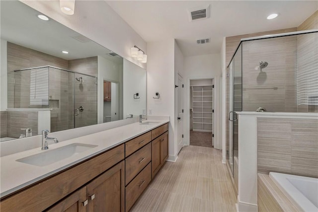 bathroom with vanity and independent shower and bath