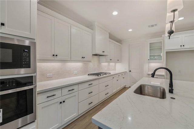 kitchen featuring white cabinets, light hardwood / wood-style floors, sink, and stainless steel appliances