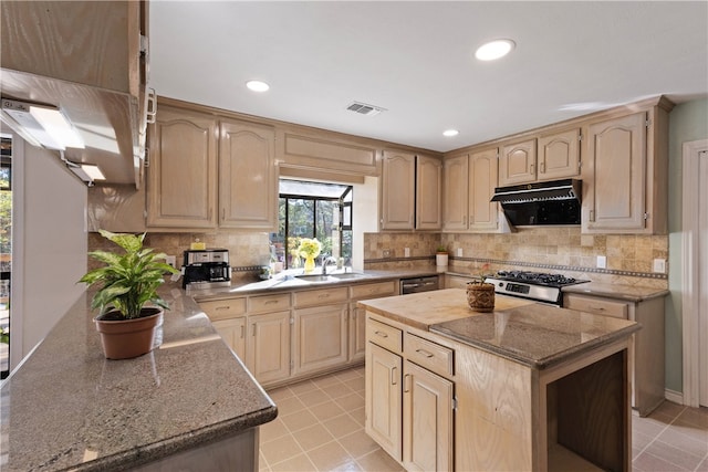 kitchen featuring light tile patterned floors, sink, extractor fan, and light brown cabinetry