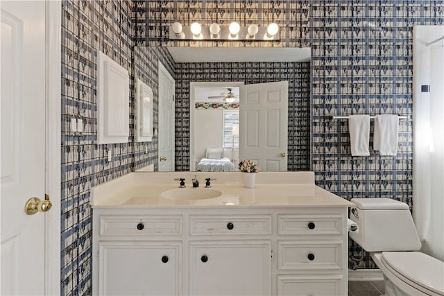 bathroom with ceiling fan, toilet, and vanity