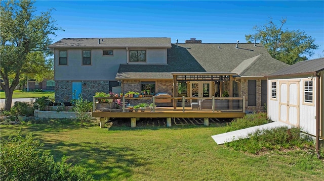 back of house featuring a yard, a storage unit, and a wooden deck