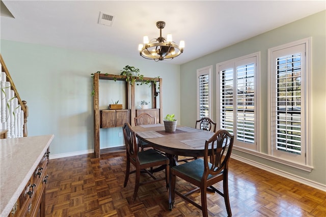 dining area with an inviting chandelier and dark parquet floors