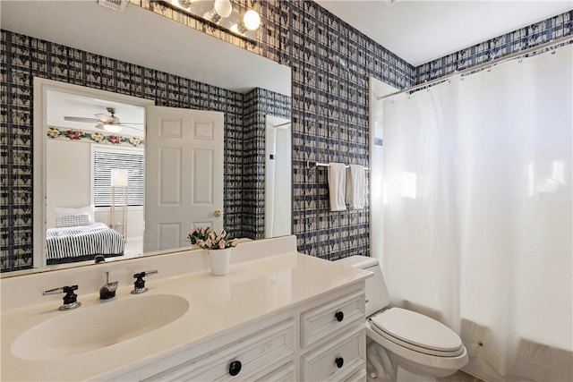 full bathroom with ceiling fan, toilet, vanity, and shower / tub combo with curtain