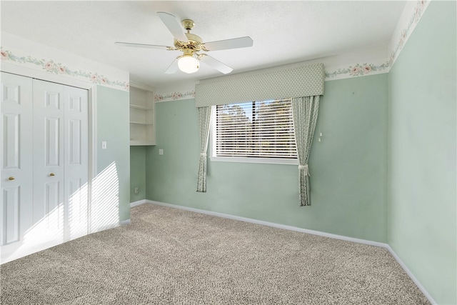 unfurnished bedroom with ceiling fan, a closet, and carpet flooring