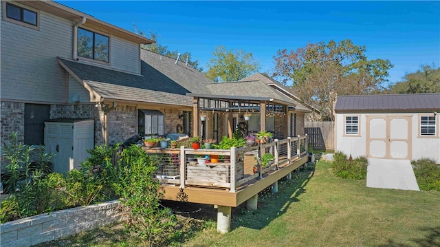 rear view of property featuring a storage shed, a deck, and a yard