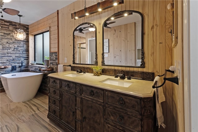 bathroom with ceiling fan, a bath, wood walls, and vanity