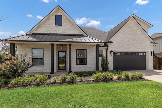 view of front of property with a front yard, a garage, and covered porch