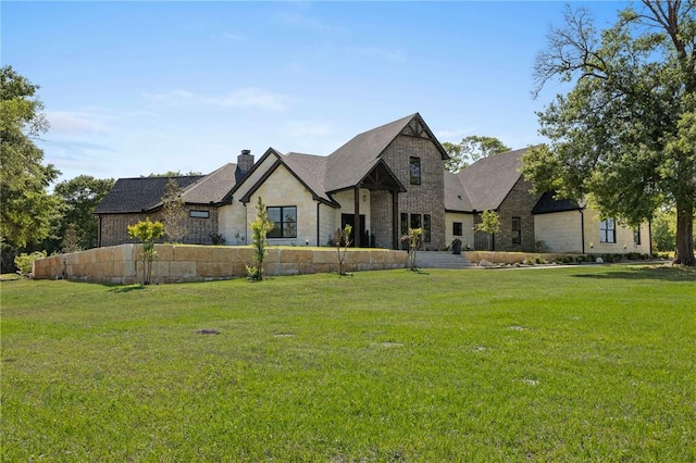 view of front of home featuring a front lawn, stone siding, and a chimney