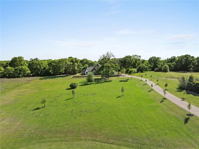 view of community with a rural view and a lawn