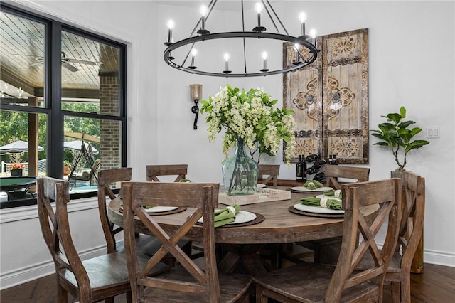 dining room featuring dark wood-type flooring, a notable chandelier, and baseboards