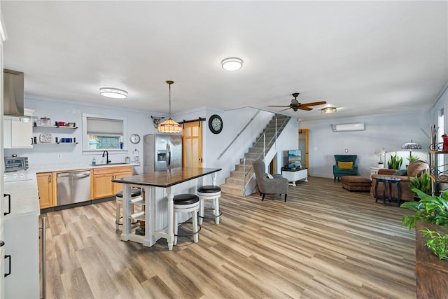 kitchen featuring light wood-type flooring, ceiling fan, open shelves, and stainless steel appliances