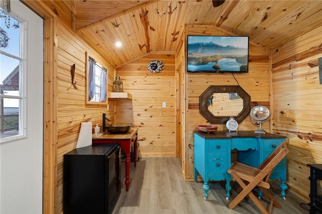 interior space featuring wood walls, vaulted ceiling, wooden ceiling, and wood finished floors