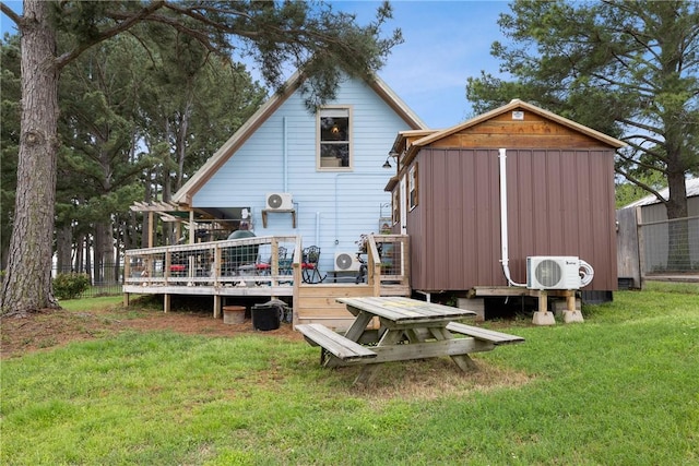 rear view of house featuring an outdoor structure, ac unit, a wooden deck, a lawn, and a storage unit