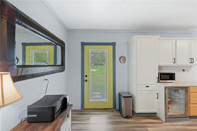 doorway to outside featuring wine cooler, plenty of natural light, and wood finished floors