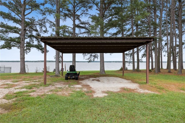 view of parking / parking lot featuring a carport and a water view