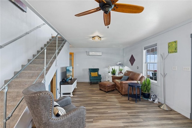 living room featuring a ceiling fan, stairway, wood finished floors, a wall mounted air conditioner, and baseboards