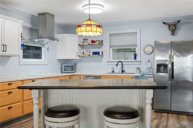 kitchen featuring a sink, appliances with stainless steel finishes, a breakfast bar area, and island exhaust hood