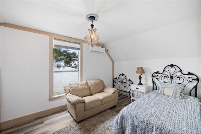 bedroom featuring a wall mounted air conditioner, baseboards, vaulted ceiling, and wood finished floors