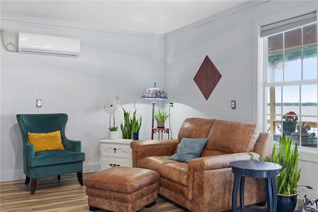 sitting room featuring a wall unit AC, wood finished floors, and baseboards