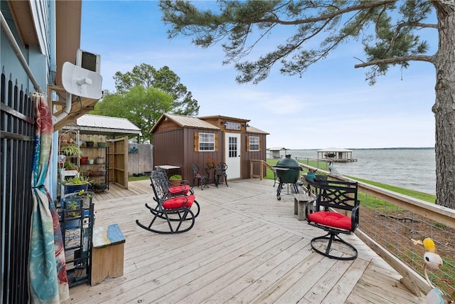 deck featuring an outdoor structure and a water view