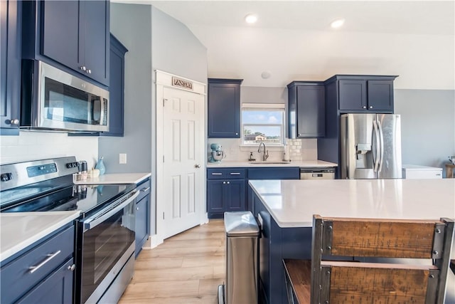 kitchen with backsplash, light hardwood / wood-style floors, sink, and stainless steel appliances