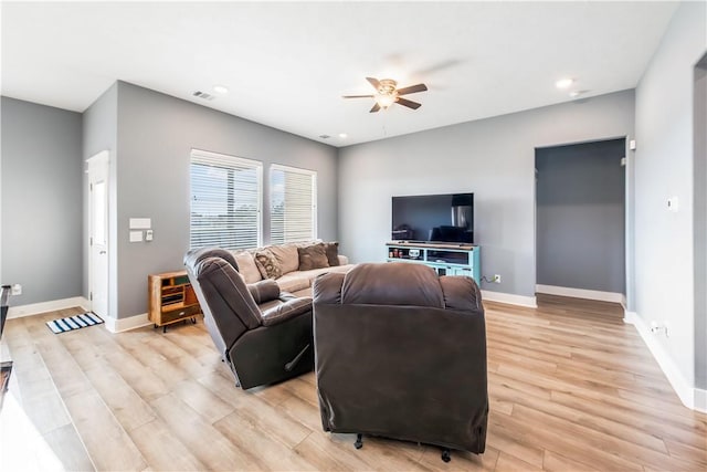 living room with light hardwood / wood-style flooring and ceiling fan