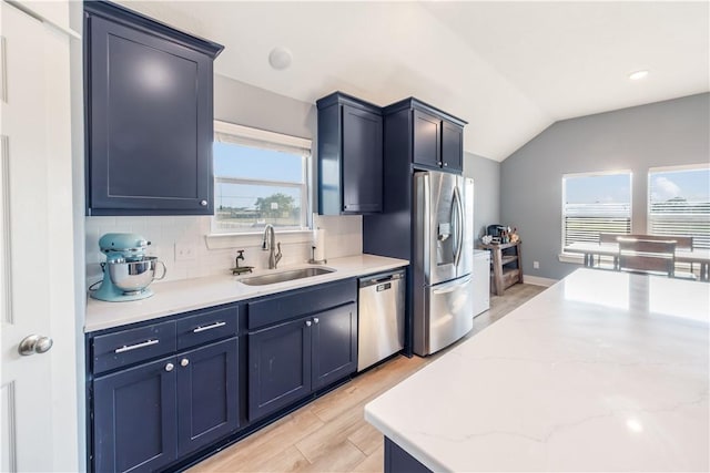 kitchen with plenty of natural light, lofted ceiling, sink, and appliances with stainless steel finishes