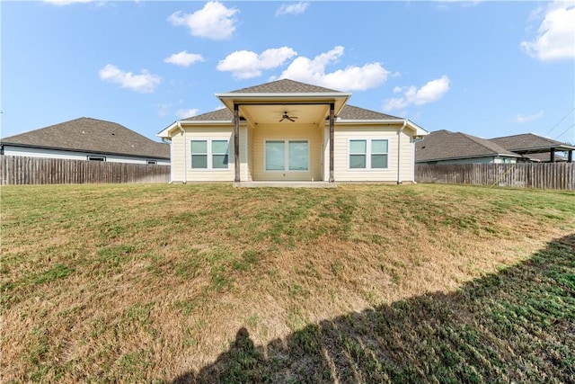 rear view of house with a yard and ceiling fan