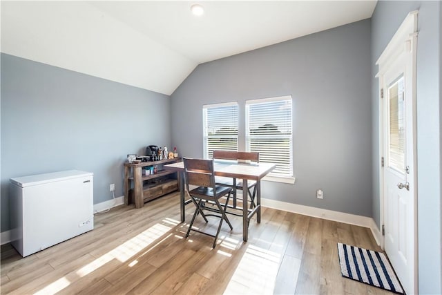 office space with light hardwood / wood-style floors and vaulted ceiling