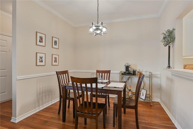 dining room featuring hardwood / wood-style flooring, crown molding, and an inviting chandelier