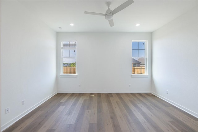 unfurnished room with hardwood / wood-style flooring, ceiling fan, and a healthy amount of sunlight