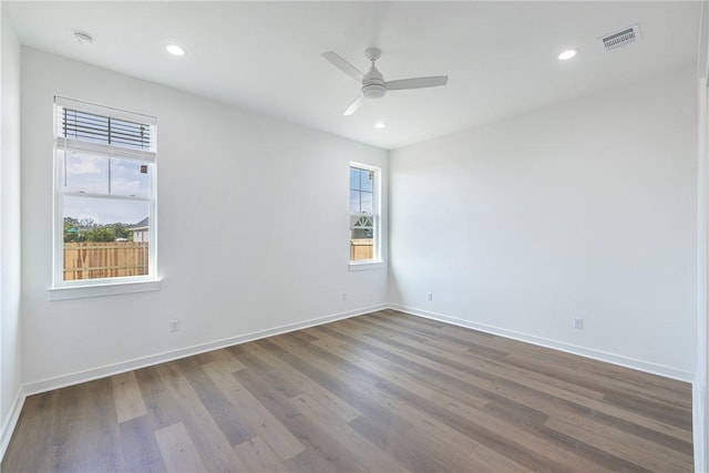 empty room with ceiling fan, hardwood / wood-style floors, and a healthy amount of sunlight