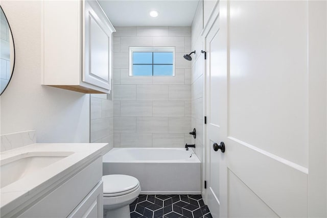 full bathroom featuring tile patterned floors, vanity, toilet, and tiled shower / bath