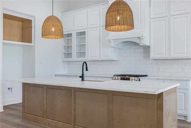 kitchen featuring white cabinetry and a kitchen island with sink