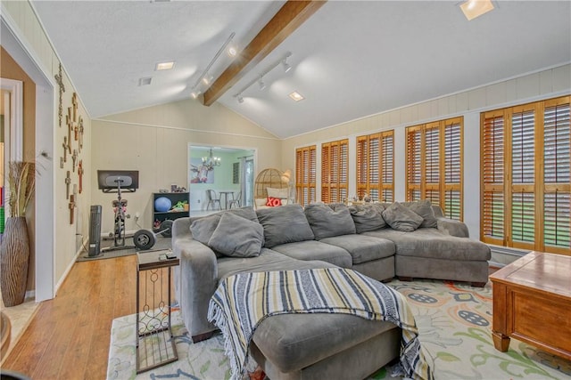 living area with vaulted ceiling with beams, an inviting chandelier, and light wood-style floors