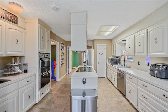 kitchen with black appliances, a sink, light countertops, and white cabinets