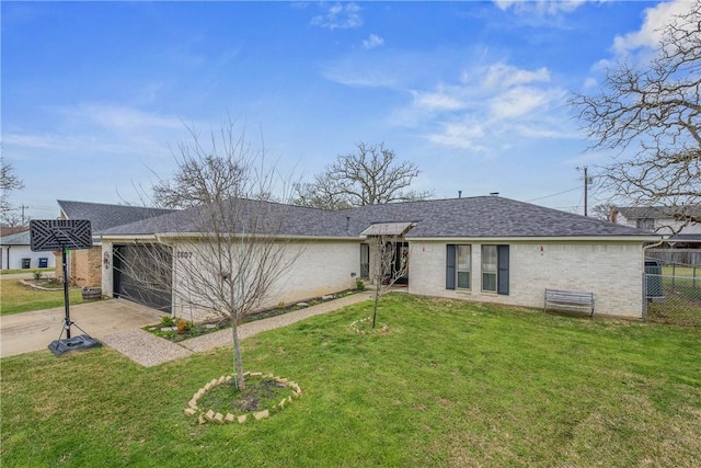 rear view of property featuring brick siding, a yard, driveway, and an attached garage