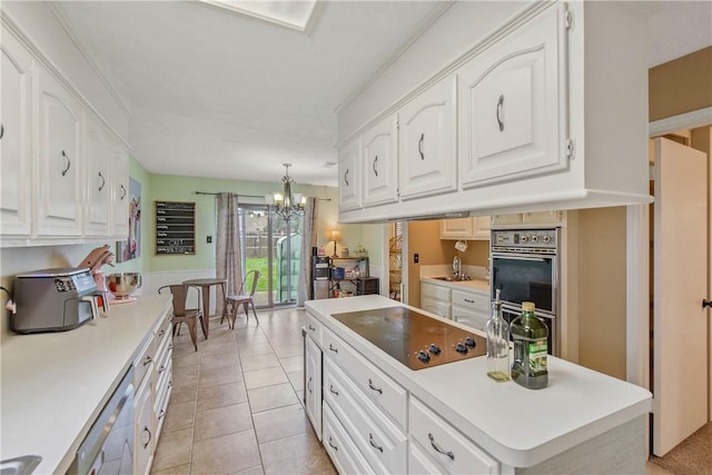 kitchen with hanging light fixtures, stainless steel appliances, white cabinetry, and light countertops