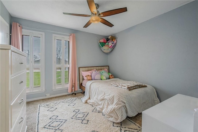 bedroom featuring light carpet, ceiling fan, and baseboards