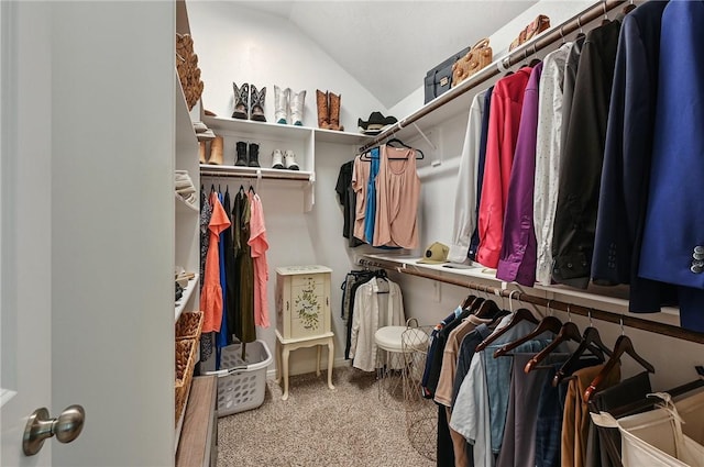 walk in closet with carpet and vaulted ceiling