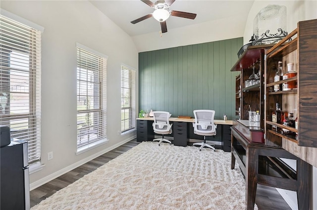 office space with vaulted ceiling, plenty of natural light, dark wood-type flooring, and ceiling fan