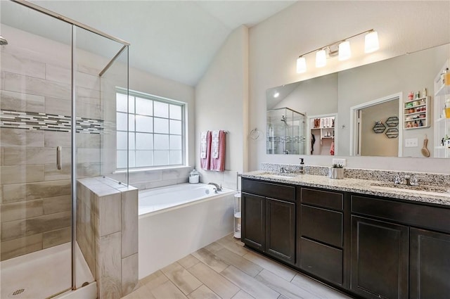 bathroom featuring separate shower and tub, vanity, and lofted ceiling