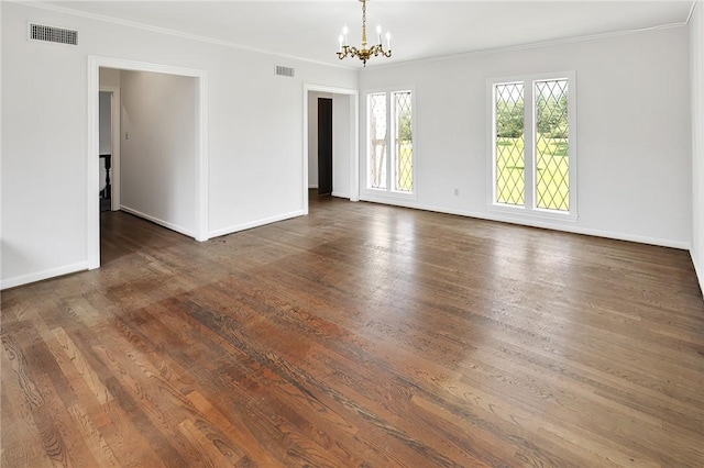 unfurnished room with a chandelier, dark hardwood / wood-style floors, and crown molding