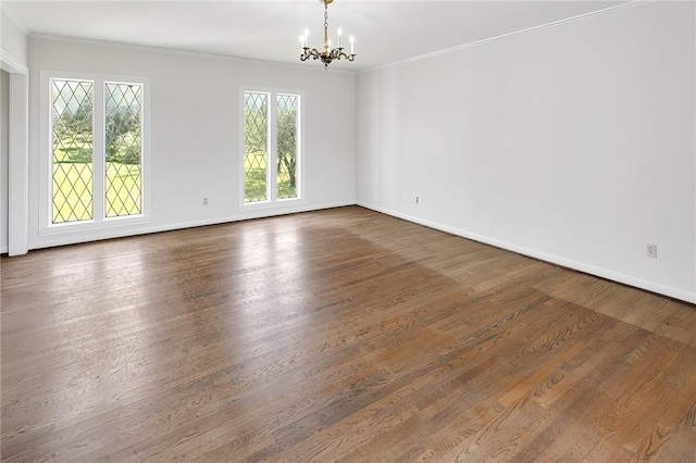 unfurnished room with crown molding, dark wood-type flooring, and an inviting chandelier