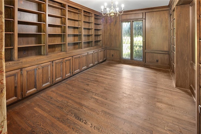 interior space with wood walls, crown molding, dark hardwood / wood-style floors, and a notable chandelier