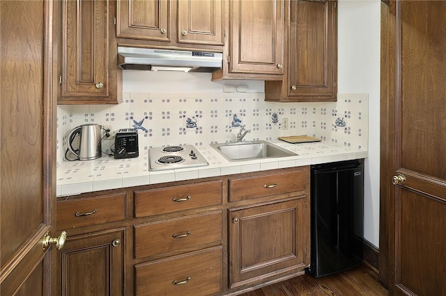 kitchen with decorative backsplash, dark hardwood / wood-style flooring, sink, white electric cooktop, and range hood