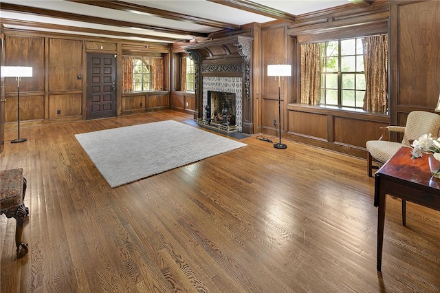 living room featuring hardwood / wood-style floors, wood walls, a fireplace, and beamed ceiling