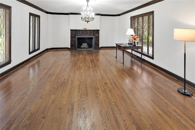 unfurnished living room featuring a notable chandelier, ornamental molding, and dark wood-type flooring