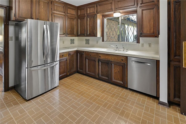 kitchen with decorative backsplash, dark brown cabinetry, sink, and appliances with stainless steel finishes